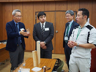 写真06:オプション企画で試作品「木のお酒」の香りを紹介している様子