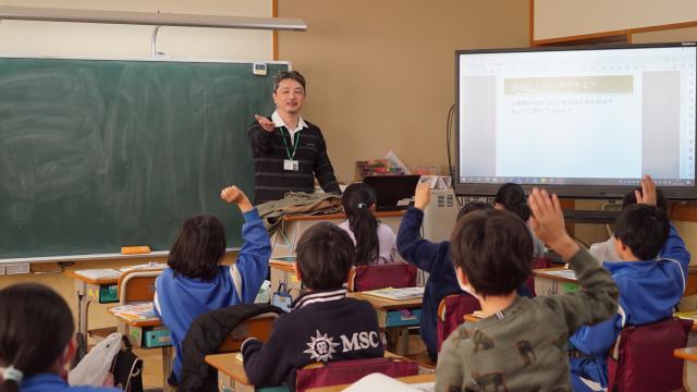 教室内で、生徒がちが次々と研究者に質問をしている様子
