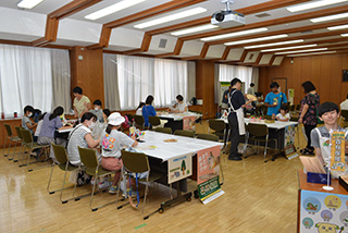 写真8.木製のうちわに色々な絵を描いて、オリジナルのうちわ作りに挑戦している様子